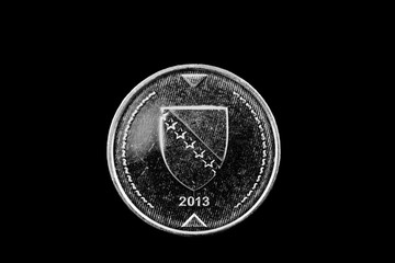 A macro image of a Bosnian 1 convertible mark coin isolated on a black background