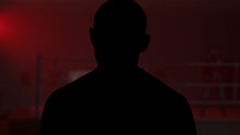 Silhouette Of A Man Who Comes Into The Room With A Red Light, Back View. Shadow Of Man In The Red Room. Silhouette Of A Man In The Light