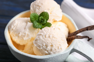 Wall Mural - Cup with delicious vanilla ice cream on table, closeup