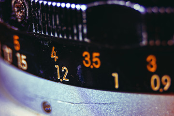 Old manual control lens body. Scratches and dirt. Close-up on the numbers of aperture ring. Concept of repair