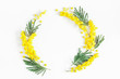 Flowers composition. Wreath made of mimosa flowers on white background. Flat lay, top view, copy space
