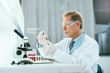 Laboratory Test. Male Doctor Analyzing Blood Sample