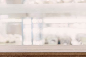 Wall Mural - Empty wooden table top with blurred modern shopping mall background for product display and montage.