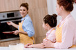 © LIGHTFIELD STUDIOS - three generations of beautiful women in aprons baking pastry together at kitchen