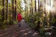 © edb3_16 - Girl wearing a bright red jacket is walking the the beautiful woods during a vibrant winter morning. Taken in Ucluelet, Vancouver Island, BC, Canada.