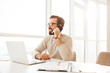 © Drobot Dean - Photo of businesslike man 30s in casual clothing enjoying talking on cell phone, while working at home