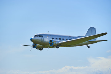 Old propeller airliner flying in cloudy sky
