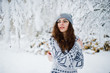© AS Photo Family - Cute curly girl in sweater and headwear at snowy forest park at winter.