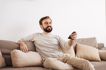 Wall Mural - Portrait of a smiling man holding remote control