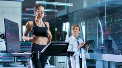 Wall Mural - beautiful woman athlete runs on a treadmill with electrodes attached to her body, female physician u