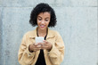 © Daniel Ernst - Latin american woman sending message with phone