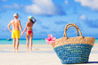 © el.rudakova - colourful straw beach bag abd hugging honeymoon couple on background