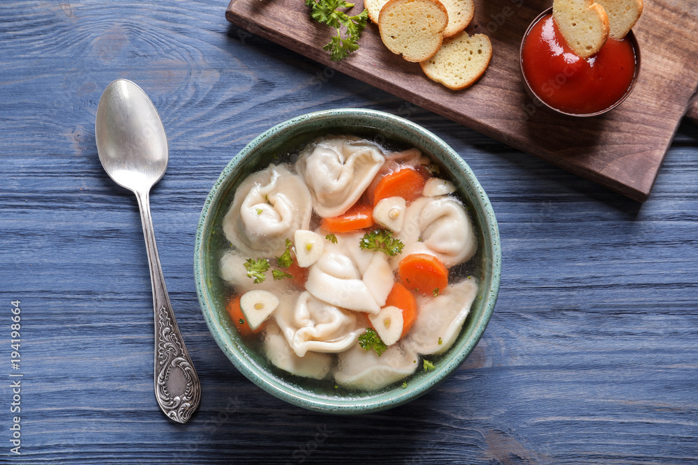 Bowl of delicious soup with dumplings on table