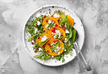 Tasty Persimmon With Cottage Cheese And Arugula On Plate