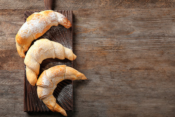 Sticker - Wooden board with tasty crescent rolls on table