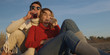 © .shock - Loving Young Couple Sitting On The Beach beside Campfire drinking beer