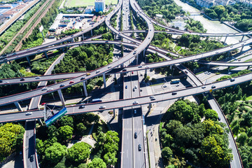 Aerial view massive highway intersection, stack interchange with elevated road junction overpass at late afternoon in Houston, Texas. This five-level freeway interchange carry heavy traffic, panorama.