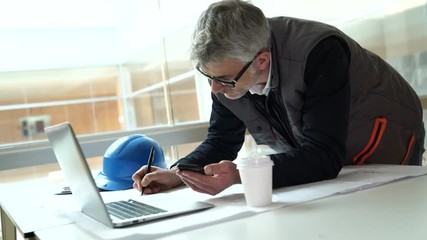 Wall Mural - Architect in office talking on mobile phone