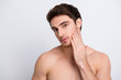© deagreez - Close up photo of handsome virile attractive confident with brown hair haircut guy with naked shoulders touching his cheek isolated on gray background copy-space