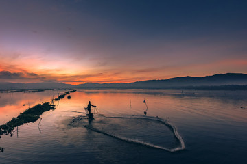 Wall Mural - Fisherman's dancing on the water in sunrise view