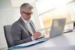 © goodluz - Businessman in office working on laptop