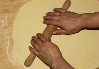 hands on rolling pins roll out the dough