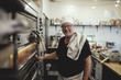 © Maskot - Portrait of baker next to oven