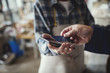 © Maskot - Cropped image of customer paying through credit card to female craftsperson