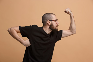 Wall Mural - The young emotional angry man on pastel studio background