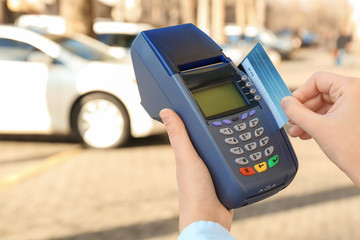 Poster - Woman using bank terminal for credit card payment outdoors