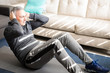 © AntonioDiaz - Active mature man exercising and doing crunches at home
