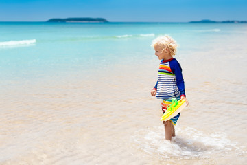 Wall Mural - Child on tropical beach. Sea vacation with kids.