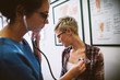© Dusan Petkovic - Adorable professional middle-aged nurse checking health condition of worried short hair patient in the clinic hospital.