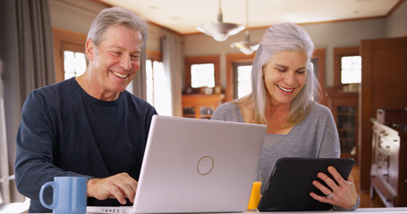 Couple of senior white people looking at tech devices