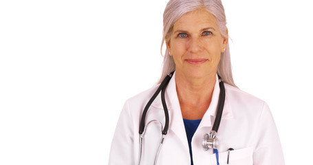 An elderly medical professional poses for a portrait on a white background. An older doctor stands on a blank backdrop