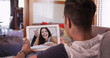 © Mark Adams - Cute millennial couple video chatting or having a facetime conversation with his girlfriend on tablet computer. Young boyfriend and girlfriend talking over video call on pad