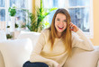 © Tierney - Young woman relaxing on a couch at home