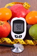 © ratmaner - Glucometer with result sugar level, centimeter and fresh fruits, diabetes and healthy nutrition concept