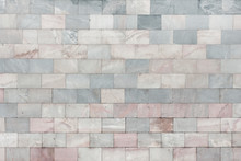 The Wall Is Made Of Marble Gray And Pale Pink Tiles. Beautiful Stone Texture. Empty Background.