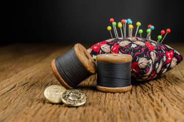 retro spool thread with pincushion on wooden board