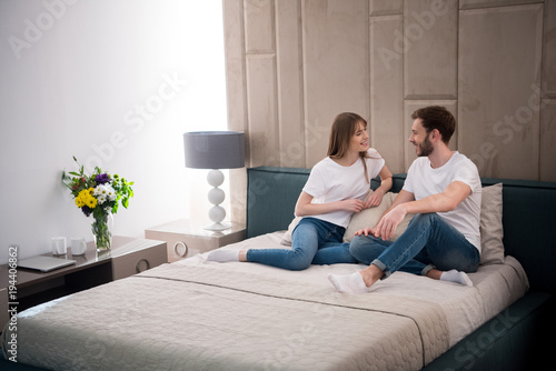 Happy Couple Sitting On Bed In Cozy Modern Bedroom Buy