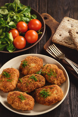 Wall Mural - Fried meat cutlets, tomatoes and salad on wooden background.