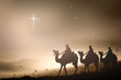 Leinwandbild Motiv Christmas religious nativity concept: Prophecy magi and his friend with three camel on desert was going to bethlehem city in christmas eve.