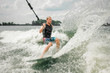 © fesenko - Young athletic man wakesurfing on the board holding a cable