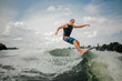 © fesenko - Handsome athletic guy wakesurfing on the board against the sky
