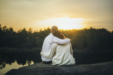 Couple Is Hugging Looking To The Sunset Sitting