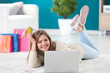 © Africa Studio - Young woman shopping online with credit card and laptop on floor