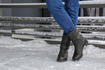 Wall Mural - Stylish woman wearing warm shoes on city street in winter