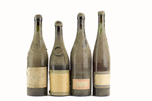 Four  Dusty Bottles Of Old Italian Wine  Lined On White Background