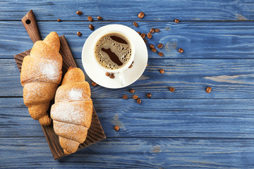 Sticker - Tasty croissants and cup of coffee on wooden table